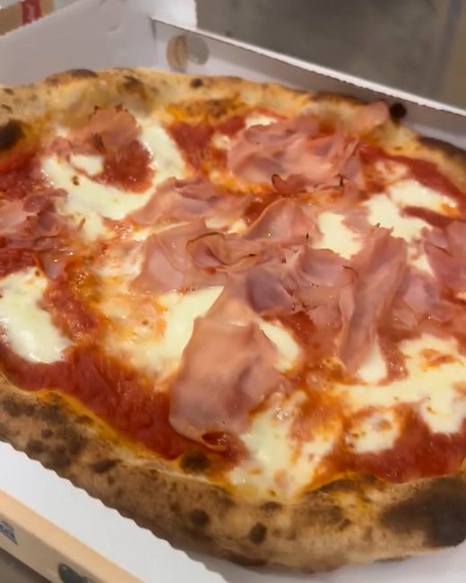 Una pizza al prosciutto cotto nel cartone